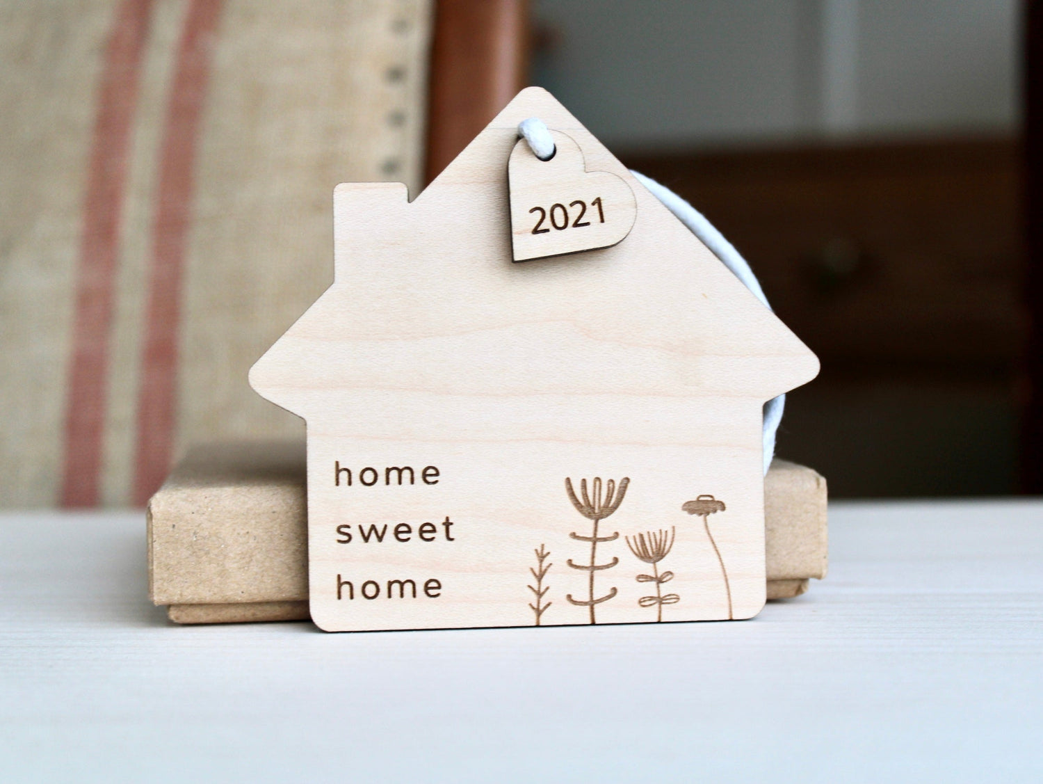 House shaped wooden decoration engraved with home sweet home and a flower design