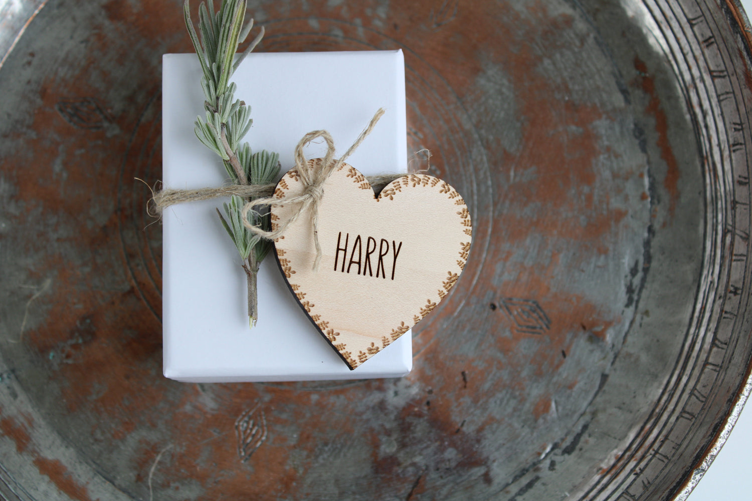 Heart shaped tag, used as a wedding place setting, engraved with a leaf border and name