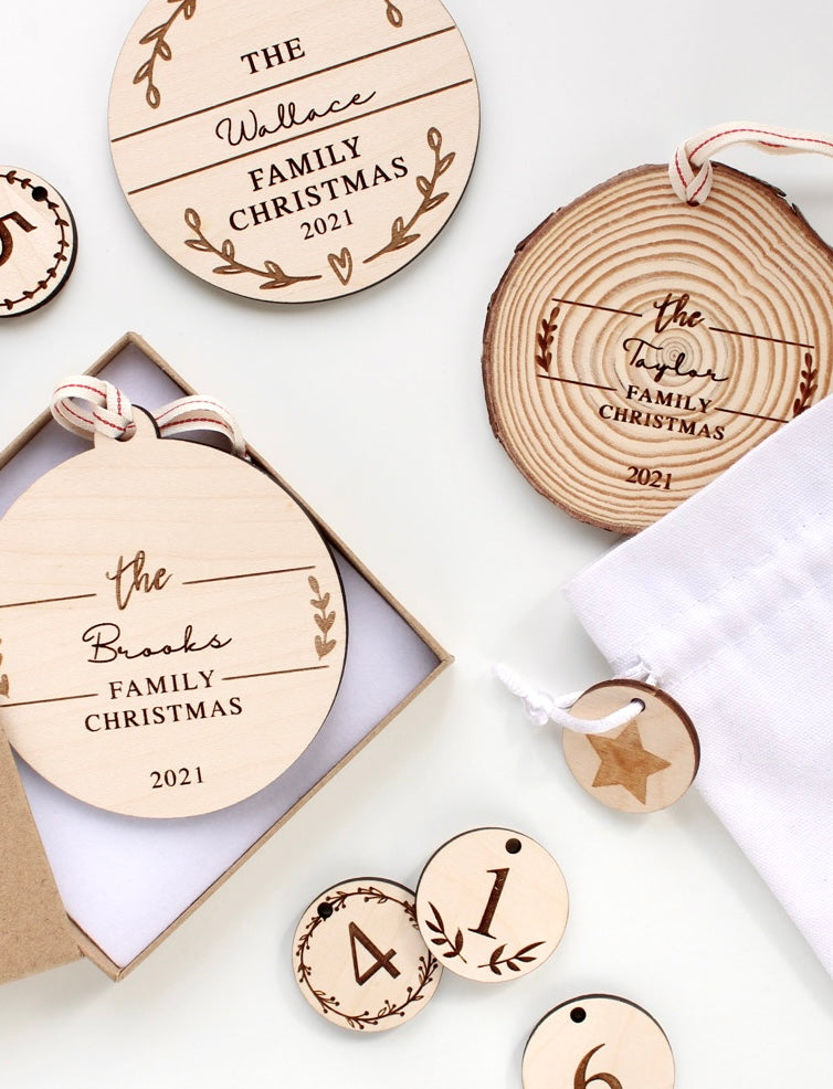 A selection of wooden laser engraved Christmas ornaments personalised with family surnames